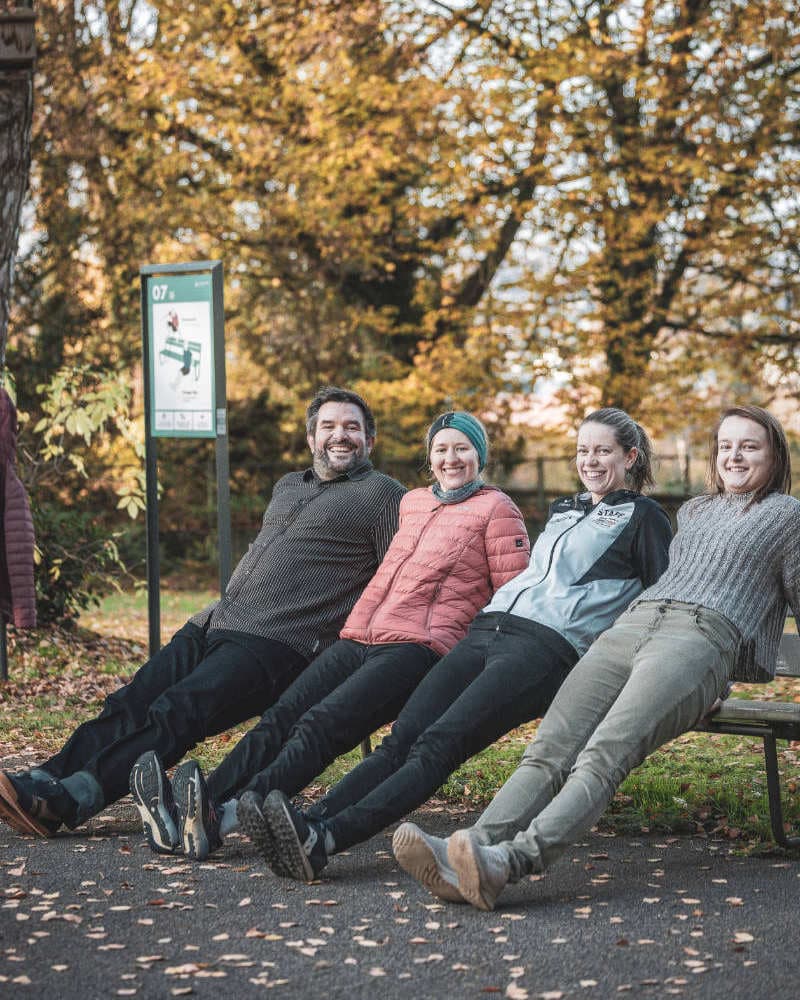 Menschen sitzen auf einer Bank im öffentlichen Raum